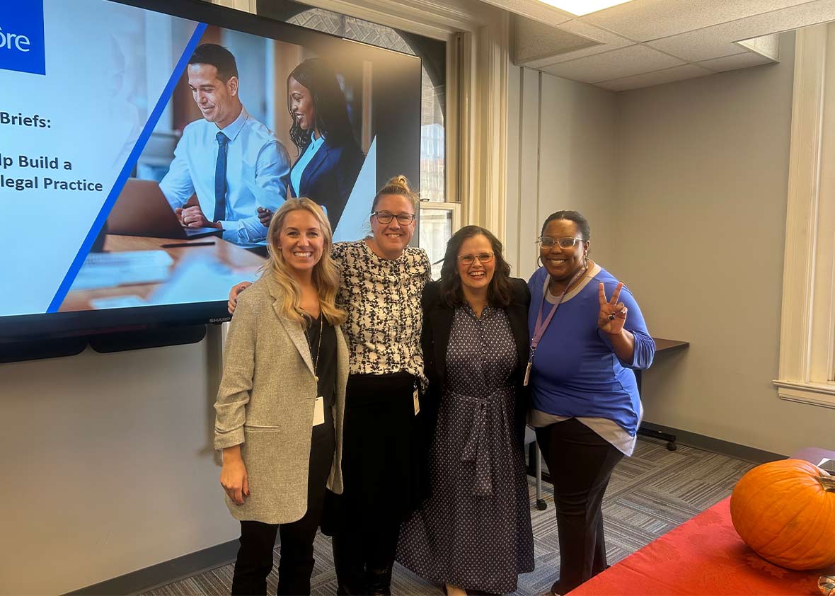 Dinsmore team members standing in front of a screen after a presentation