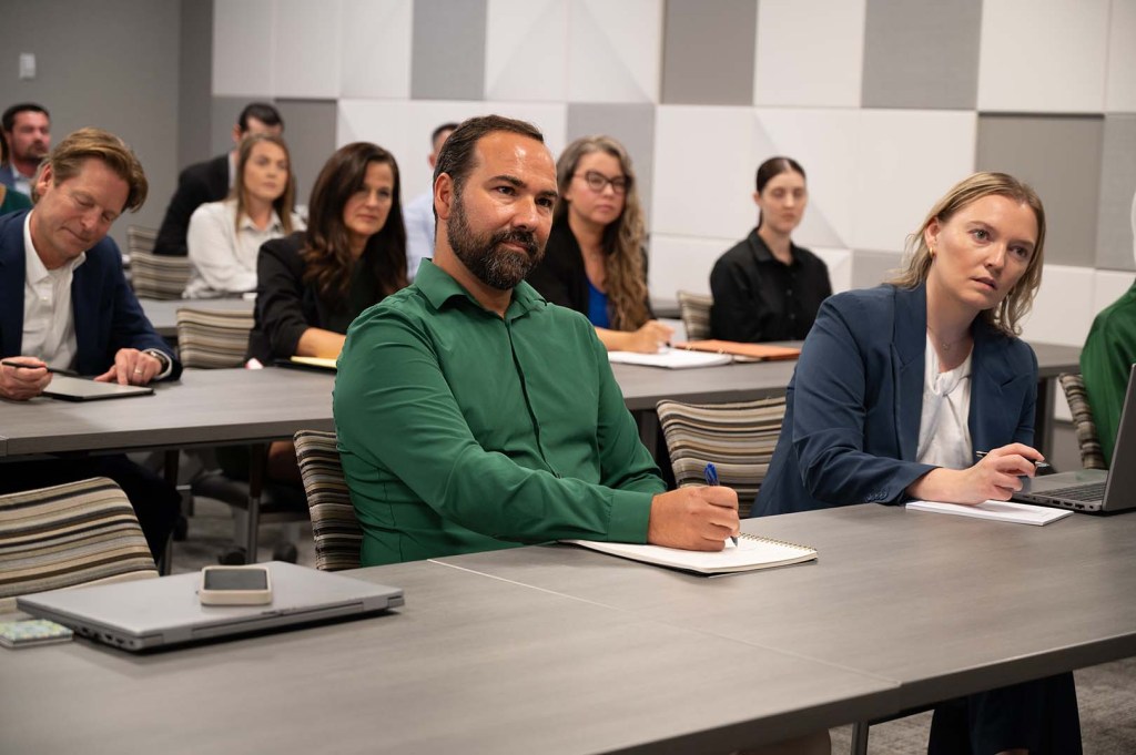 Man in green sitting at table